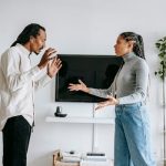 Annoyed young ethnic couple quarreling in cozy apartment